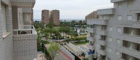 Un edificio residencial de gran altura con diseño arquitectónico moderno, que cuenta con balcones y un patio central.