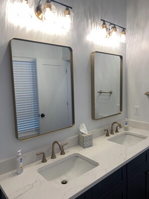 A bathroom with two sinks, a mirror, and a towel dispenser. - BRAND NEW 4 bedroom 3.5 bath retreat in Williamstown, KY with large rooftop deck (Williamstown)