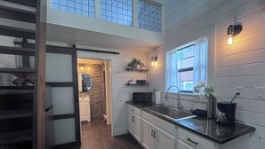 Una cucina moderna con una grande isola, un lavello doppio e vista sul piano superiore.