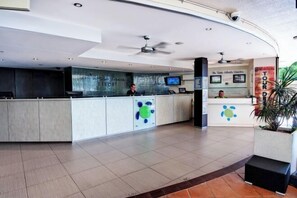 A modern reception area with a glass partition, a digital screen, and a sign for 'The Tides South Resort'. - Turtle Beach Resort (Mermaid Beach)