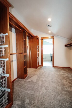 A hallway with wooden closets and a carpeted floor.