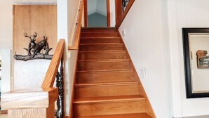 A wooden staircase with a railing, leading to a room with a framed picture on the wall. - Mayfield Lake Waterfront Escape (Mossyrock)