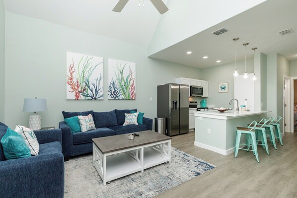 A modern living room with a sofa, coffee table, and artwork on the wall.
