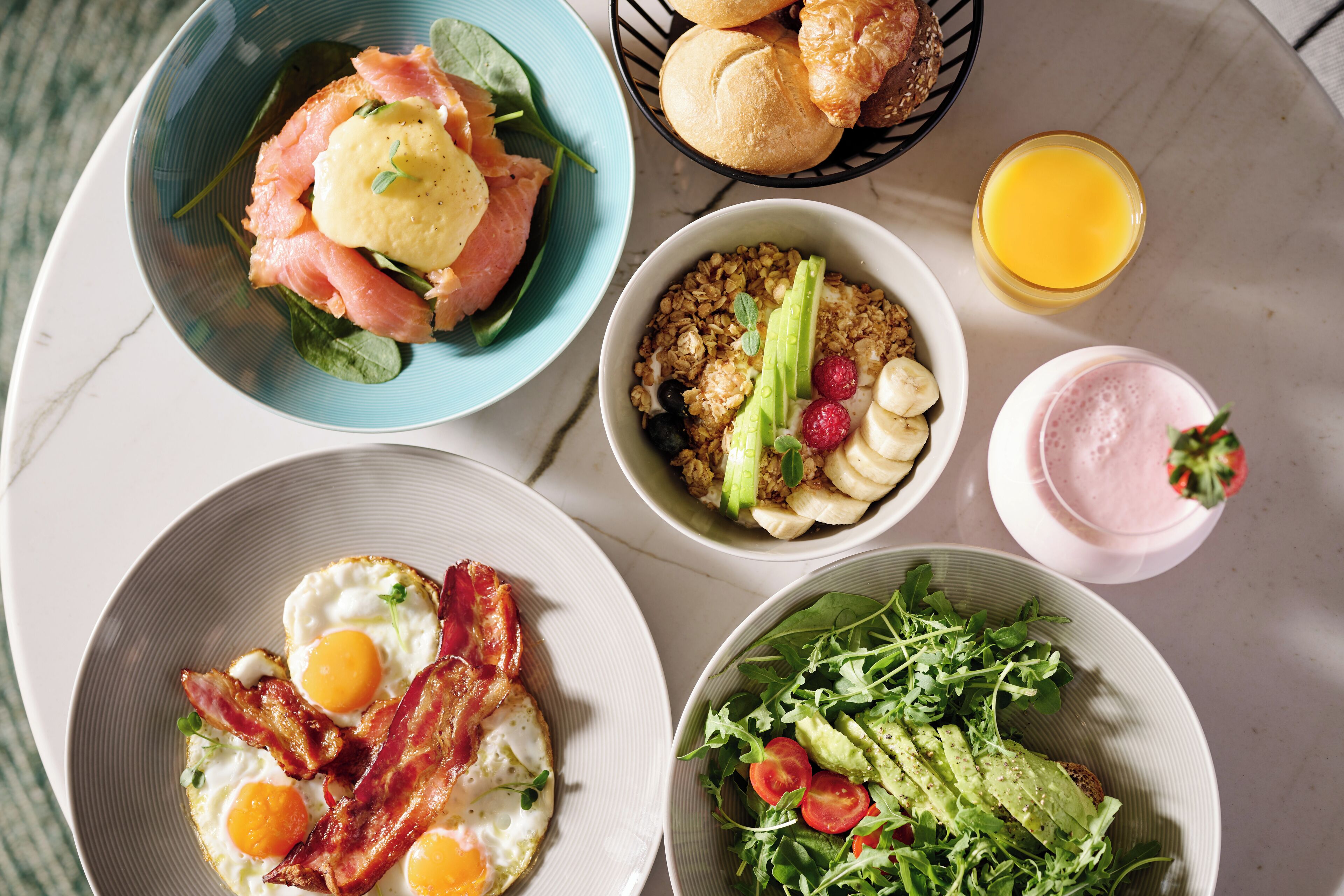 A breakfast spread with various dishes including eggs, bacon, and salads.