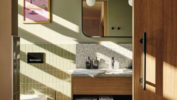 A modern bathroom with a wooden vanity, a sink with a speckled countertop, and a framed picture on the wall.