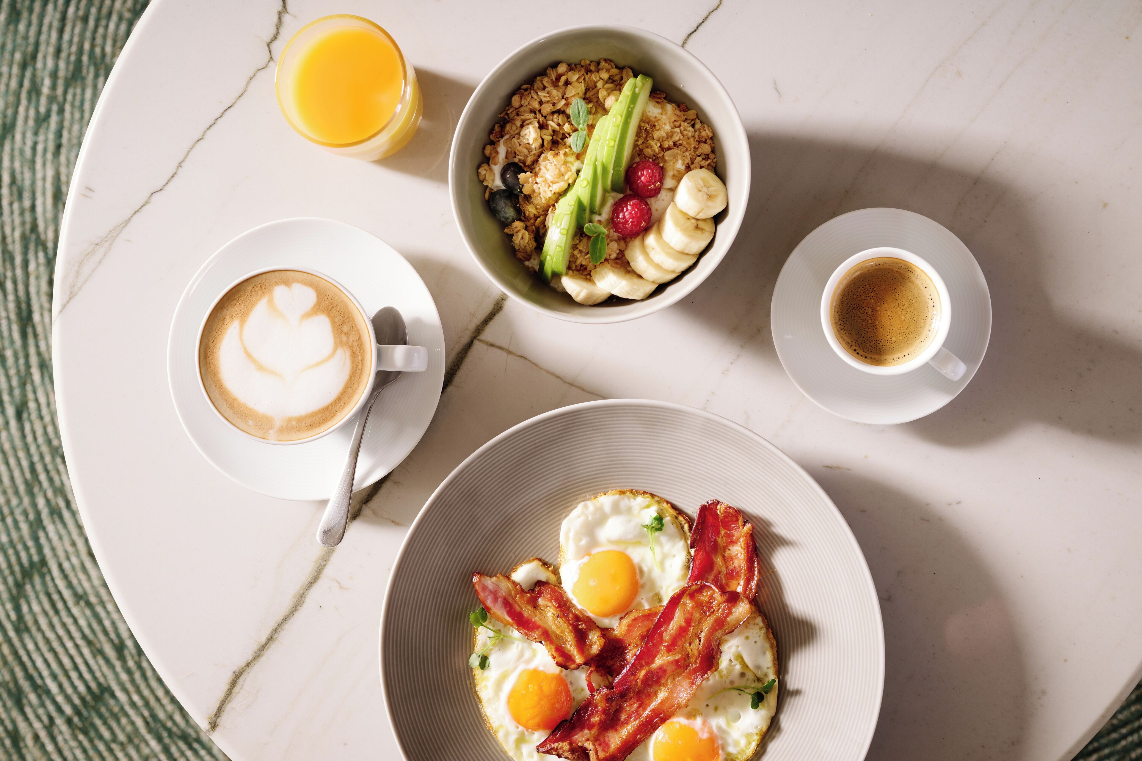 A breakfast tray with cereal, fruit, eggs, and coffee.