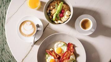 A breakfast tray with cereal, fruit, eggs, and coffee.