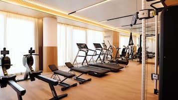 A gym with treadmills, elliptical machines, and weight benches.