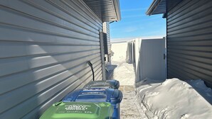 Un étroit sentier entre les bâtiments, la neige recouvrant le sol.