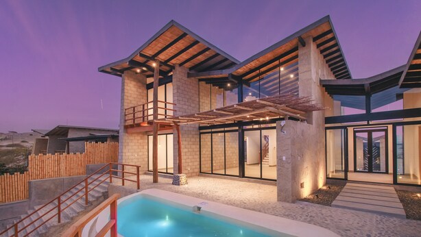 Una casa moderna con piscina, ventanas amplias y terraza de madera.