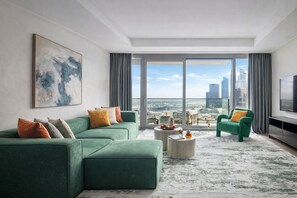 Een moderne woonkamer met een groene bank, een salontafel en een televisie.
