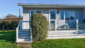 A single-story building with a white exterior, a small front porch with steps, a door, and a window. - 2 bedroom accommodation in Lowestoft (Lowestoft)