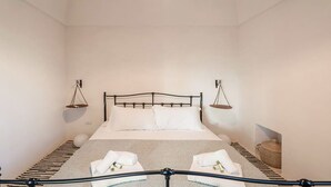 A bedroom with a bed, pillows, a bedside table, and a hanging light fixture. - Unity House Sleeps 4 with terrace - Masseria 1 by Rentbeat (Ceglie Messapica)