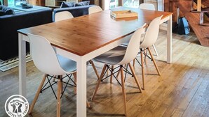 A wooden cabin interior with a dining area, sofa, and staircase. - Gîtes de France® - The Chalet (PINSAC)