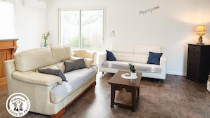A living room with two sofas, a coffee table, and a wall-mounted lamp.