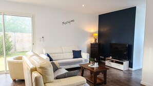 A living room with a sofa, a coffee table, a TV, and a lamp.