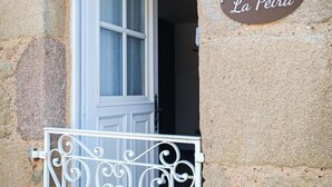 A stone building with a white door and a metal gate. A sign above the door reads "19 La Péira." - Gîtes de France® - La Pèira (LATRONQUIERE)