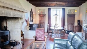 Una sala de estar acogedora con chimenea, sofá de cuero, muebles de madera y un comedor.