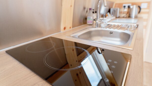 A modern kitchen with built-in appliances, including a stove, sink, and dishwasher.