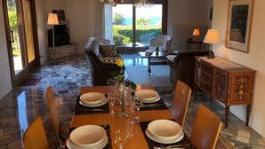 A dining area with a table set for four, a chandelier, and a view of the outdoors. - Mirabella villa with pool and garden  in Brezzo di (Brezzo di Bedero)