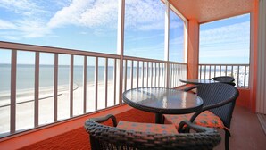 Ein Balkon mit Blick auf Strand und Meer.