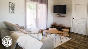 Ein modernes Wohnzimmer mit einer Couch, einem Couchtisch und einem Fernseher.