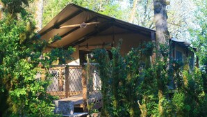 Eine rustikale Holzhütte mit einer Holzdiele, umgeben von dichtem Wald.