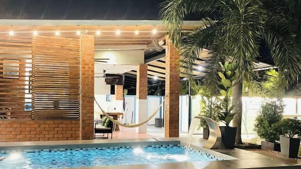 A pool area with a water feature, surrounded by brick walls and palm trees. - Rooma Kichi Private Pool (Langkawi)