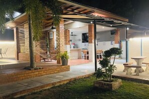 A covered outdoor area with a brick wall, a hammock, and a dining table. - Rooma Kichi Private Pool (Langkawi)