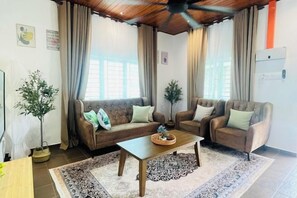 A living room with a sofa, armchairs, a coffee table, and a ceiling fan. - Rooma Kichi Private Pool (Langkawi)
