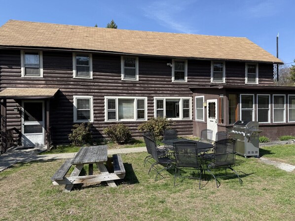 A log cabin with a front porch, a grill, and a picnic table. - Charming Cabin in Fishkill! (Fishkill)