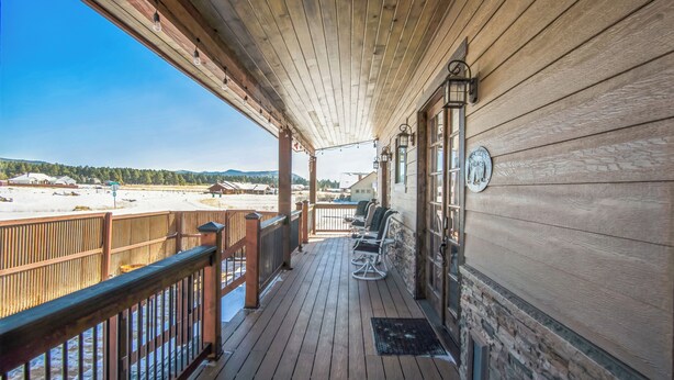 A wooden deck with outdoor seating and a view of a snowy landscape. - New, Amazing, Cozy, Jacuzzi, Mountain Views, Minutes 2 Downtown, Snow Bowl (Flagstaff)