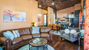 A cozy living room with leather sofas, a coffee table, and a painting on the wall. - New, Amazing, Cozy, Jacuzzi, Mountain Views, Minutes 2 Downtown, Snow Bowl (Flagstaff)