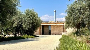 A building with a stone facade, a metal chimney, and a door leading to an interior. - Cozy home in Chiaramonte Gulfi (Chiaramonte Gulfi)