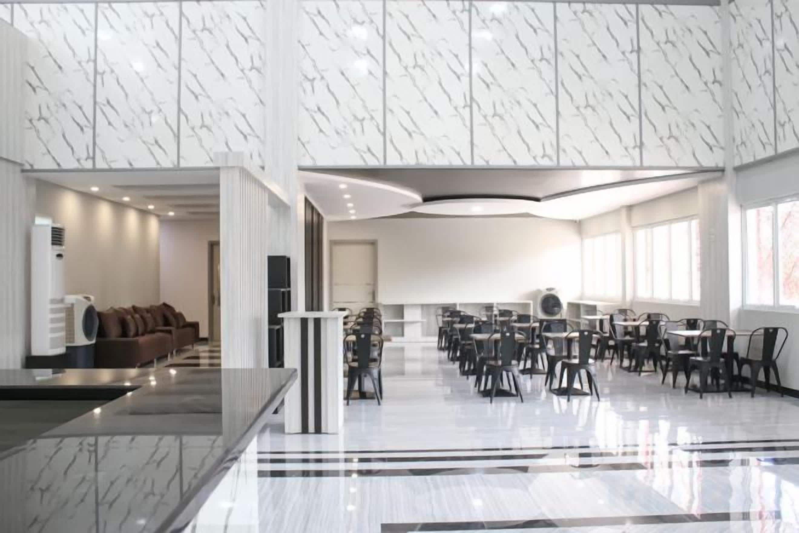 A spacious lobby with a marble floor, seating area, and a reception desk.