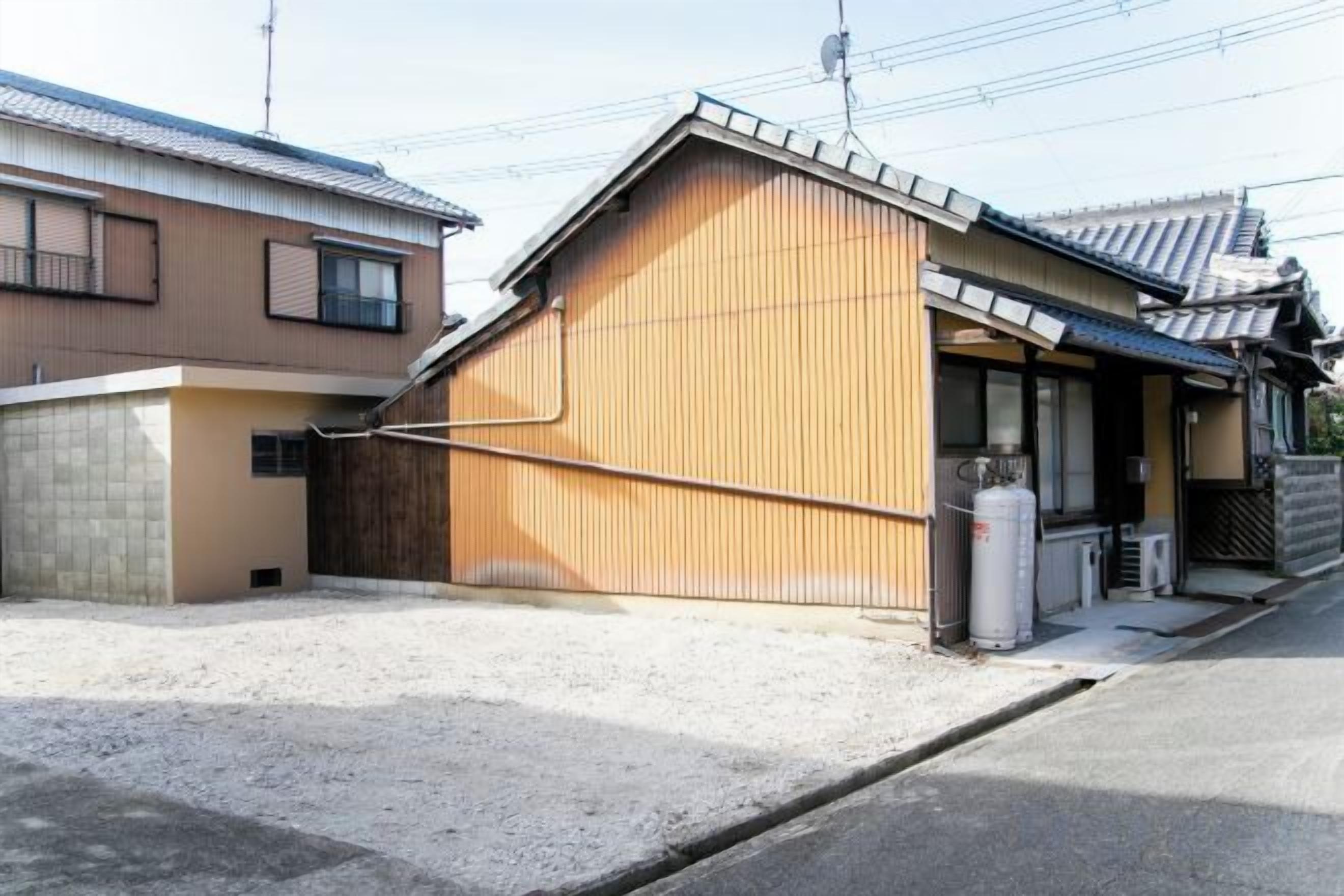 A residential building with a sloped roof, a wooden exterior, and a small attached structure.