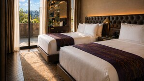 A hotel room with two beds, a large window, a minibar, and a view of the city. - Whisky Hotel  (Los Angeles)