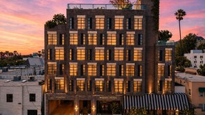 A multi-story hotel with a modern architectural design, featuring a prominent entrance and a parking area. - Whisky Hotel  (Los Angeles)