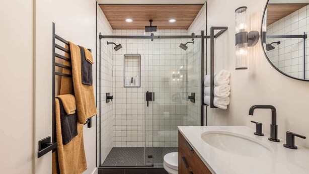 A modern bathroom with a glass-enclosed shower, a white sink with black fixtures, and a wooden ceiling. - Slopeside Suite at Alyeska - Ski In Ski Out (Girdwood)