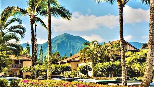 A resort with multiple buildings, palm trees, and a mountain in the background. - Chic Aloha Studio in Superb Princeville, w/AC & WiFi 
Explore Beautiful Napali! (Princeville)