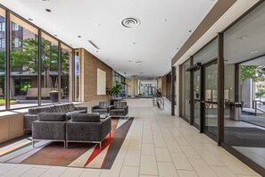 Un vestíbulo moderno con zona de estar, ventanas amplias y vistas al exterior.