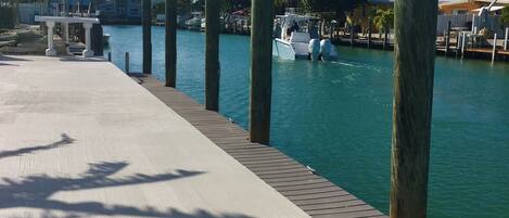 A waterfront dock with boats, a clear sky, and a wooden walkway.