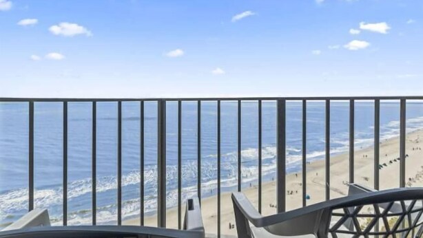 Ein Balkon mit Blick auf den Strand und das Meer.