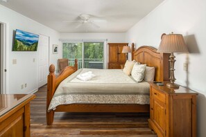 A bedroom with a bed, wooden nightstand, lamp, and a ceiling fan. - Charming Mountain Home with a View (Seven Devils)