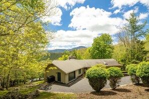 A single-story house with a sloped roof, a front porch, and a driveway leading to the entrance. - Charming Mountain Home with a View (Seven Devils)