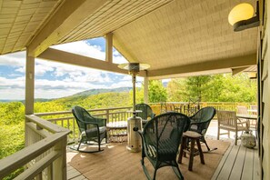 A covered outdoor area with chairs and a table, overlooking a mountainous landscape. - Charming Mountain Home with a View (Seven Devils)