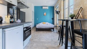 A compact room with a kitchenette, a bed, and a small table with stools. - Superb flat in beautiful Bordeaux stone for 2p (Bordeaux)