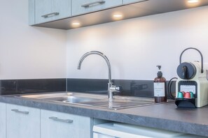 Een moderne keuken met een roestvrijstalen spoelbak, een kraan en een waterfilterinstallatie.
