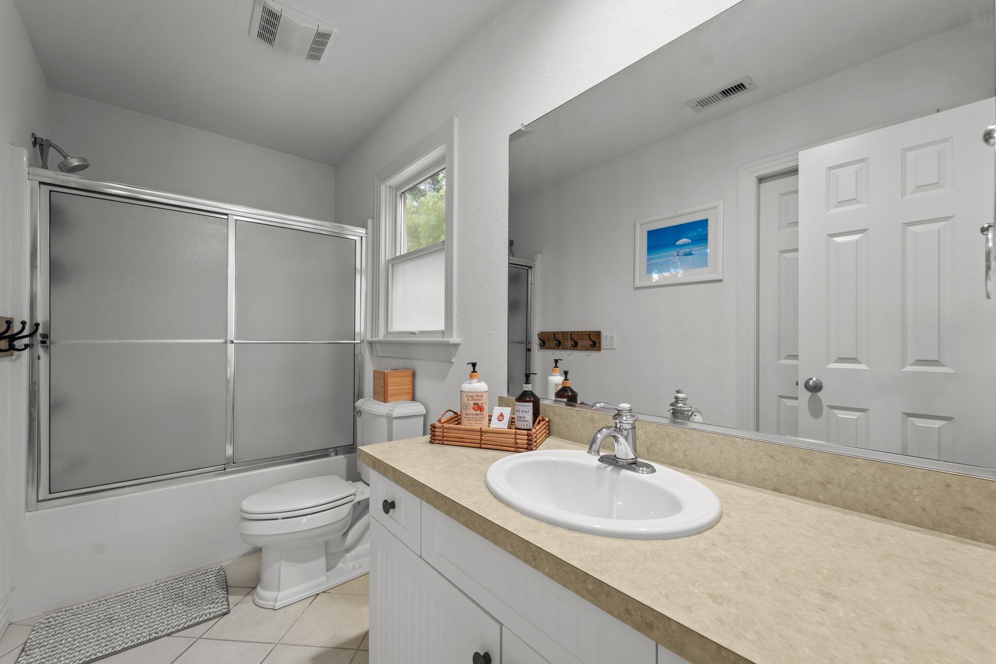 A modern bathroom with a shower, toilet, and sink.