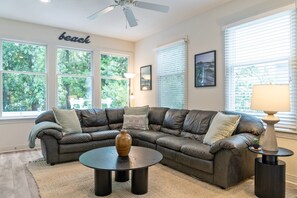 A living room with a sectional sofa, a coffee table, and a ceiling fan. - Walk on Water: Soundside, Community Pool and Clubhouse Access (Kill Devil Hills)
